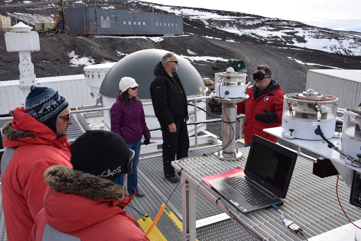Photo: Principal Investigator Dan Lubin (right) and ARM Facility Manager Kim Nitschke (center) give NSF Representative Jessie Crain a tour of the AMF-2 rooftop installation. Instruments in the foreground are the SKYRAD radiometers. Instruments in the background are the Beam-Steerable Radar Wind Profiler (BSRWP) and the Ka-band ARM Zenith Radar (KAZR). Photo taken and given as a courtesy by Heath Powers (LANL) - 20 November 2015